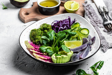 bowl salad with halloumi cheese, avocado, cucumber, chickpeas, watermelon radish, potato purple sweet. Buddha bowl, healthy and balanced food. top view