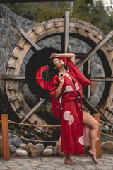 Portrait of sexy and young japanese girl with beautiful old traditional red kimono and handmade red...