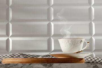 A cup of coffee on a marble table in the kitchen in the glow of the morning sun with a free space