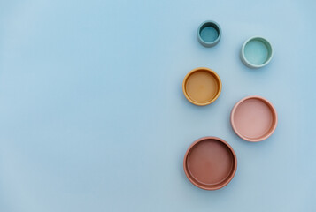 Educational Montessori toys on light blue background. Top view, flat lay. Childrens trendy silicone toys for develop hand motor skills.