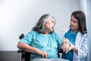 Asian woman doctor take care and encourage elderly patient Which sat on wheelchair, which she is saddened from depression, to elderly and  health care concept. - obrazy, fototapety, plakaty