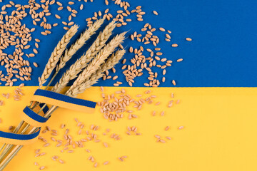 Ears of wheat and grain around over Ukrainian flag. Global and European food crisis. World wheat...