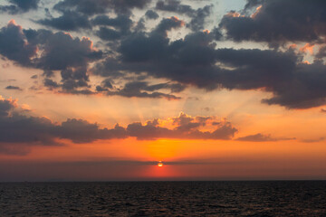 Beautiful  sea sunset in the Gulf of Thailand.  The setting sun has set behind a cloud.