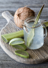 Coconut water with aloe vera mixed in, surrounded by pieces of aloe.