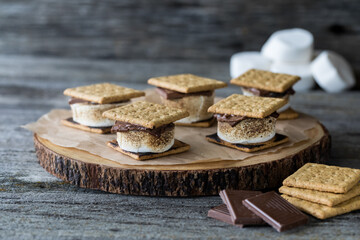 marshmallow smore's on a wooden board, ready for eating.