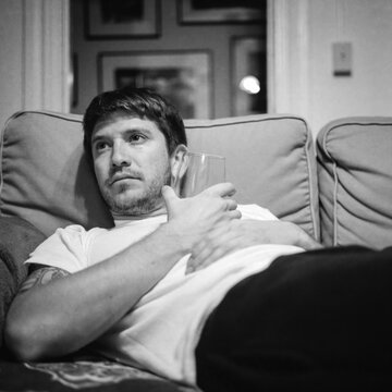 portrait of a young man on sofa with wine glass