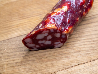 Smoked sausage on a wooden cutting board, food close-up shot. Sausage with a lot of fat. Delicacy...