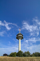Radio tower on a mountain with a mountain hut and meadows and hedges