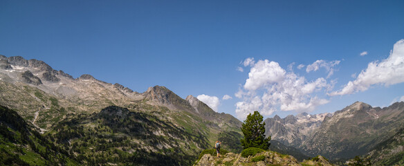 Fototapeta na wymiar Hiker woman on top of a mountain watching mountainous landscape of Pyrenees