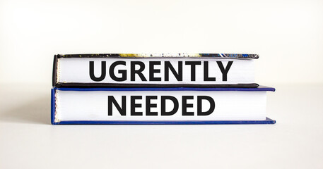 Urgently needed symbol. Concept words Urgently needed on books on a beautiful white table white background. Business and urgently needed concept. Copy space.