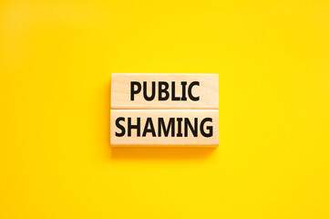 Public shaming symbol. Concept words Public shaming on wooden blocks on a beautiful yellow table yellow background. Business and public shaming concept. Copy space.