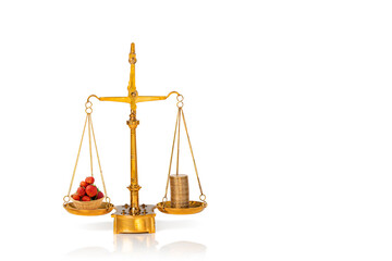 Strawberry and stacked golden coins on weighing scales isolated on white background. Copy space.