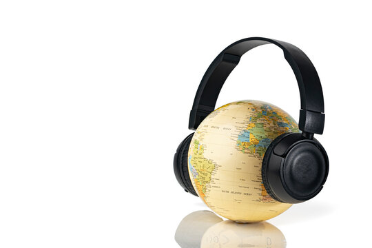 Black wireless  headphones on globe isolated on white background. Travel concept with music.