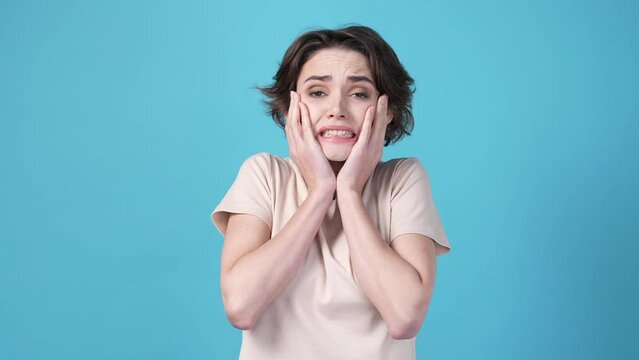 Lady terrified about horror series isolated on blue color background
