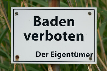Verbotsschild an einem See in Deutschland mit den Worten Baden verboten, der Eigentümer