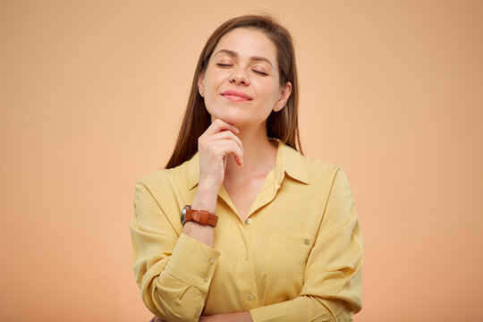 Smiling dreaming woman with eyes closed, isolated portrat on studio yellow background.