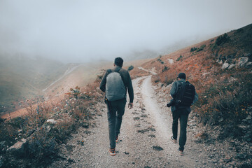 tourist with a backpack walking in the mountains in the fog