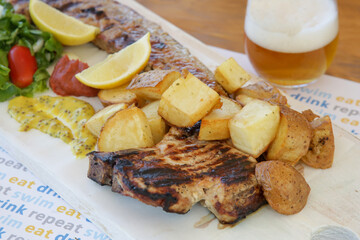 Pancetta pork belly steak served with crispy potatoes and honey mustard