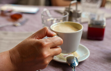 Woman holding morning cup of coffee.