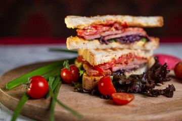 close-up sandwich of two bread toasts with stuffing and vegetables on a wooden board top view