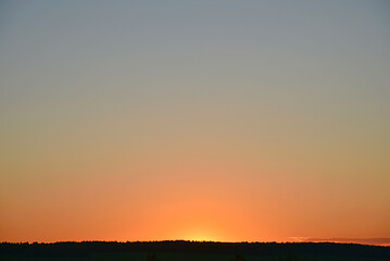 Obraz premium A clear evening sunset with blue and yellow reflections. Beautiful clear sunset.