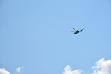 A white Mi-8 helicopter in the daytime sky. A flying cargo helicopter.