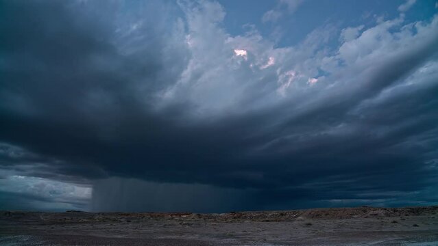 Lightning flashing in monsoon storm building in the Utah desert at dusk near Hanksville.