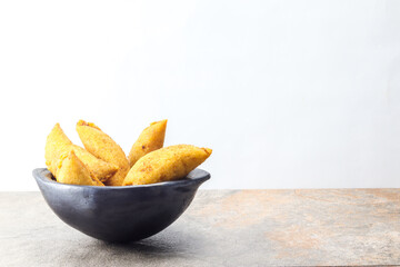 corn empanada typical Colombian food in a clay pot with copy space