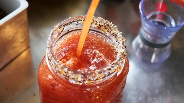 Barman fills a cocktail with tomato juice 