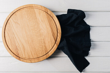 Empty round kitchen board on white wooden background.