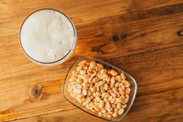 Beer in a bottle with dry salty snack, on a wooden table with free space.