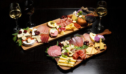 Wine and charcuterie and cheese board with a place for text. Prosciutto di Parma ham, blue cheese. Italian appetizers or antipasto set with gourmet food on table top view. Mixed delicatessen