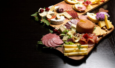 Mixed delicatessen with charcuterie and cheese board with a place for text.  Space for banner, logo, copy space. Italian appetizers or antipasto set with gourmet food on table 