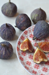 a lot of figs on a red plate and table