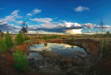 landscape with lake and storm clouds in the evening in the spring in countryside