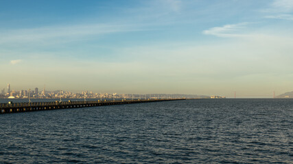 Fototapeta na wymiar Berkeley pier view of bay waters and skyline of city and Golden Gate Bridge