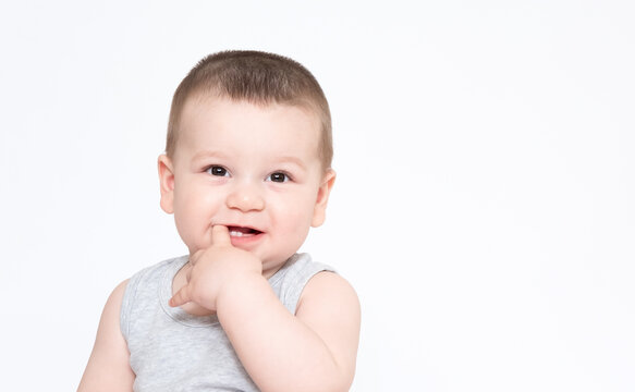 Image of cute baby boy, closeup portrait of adorable child isolated on white background, sweet toddler healthy childhood, perfect caucasian infant, lovely kid, finger in mouth teeth concept