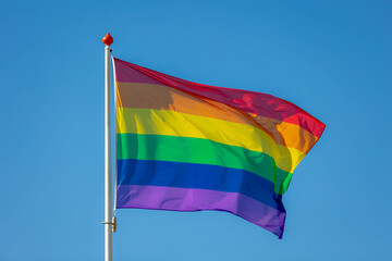 Celebration of pride month, Colourful rainbow flag hanging waving in the air with blue sky as background, Symbol of Gay, Lesbian, Bisexual and Transgender, LGBTQ community, Worldwide social movements.