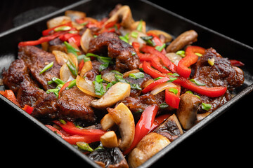 Stewed veal with vegetables and mushrooms in a frying pan. With selective focus