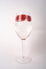 Wine glass with sparkling water and raspberries