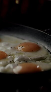 Close up someone seasoning frying eggs 