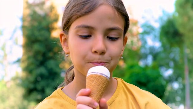 A child eats ice cream in the park. Selective focus.