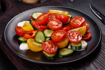Fresh, delicious salad with cherry tomatoes, cucumbers, sweet peppers, cheese and olive oil
