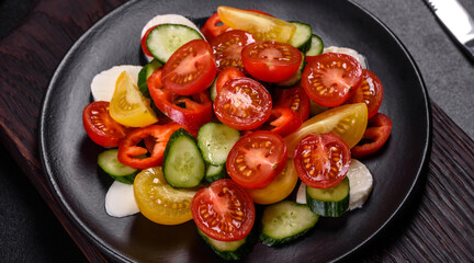 Fresh, delicious salad with cherry tomatoes, cucumbers, sweet peppers, cheese and olive oil