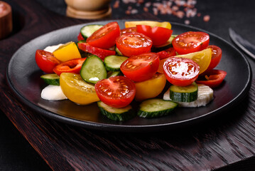 Fresh, delicious salad with cherry tomatoes, cucumbers, sweet peppers, cheese and olive oil