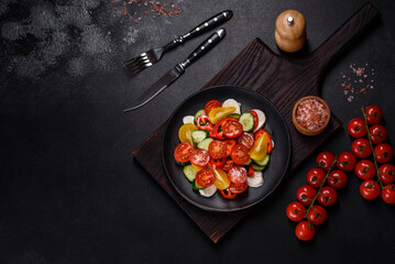 Fresh, delicious salad with cherry tomatoes, cucumbers, sweet peppers, cheese and olive oil