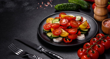 Fresh, delicious salad with cherry tomatoes, cucumbers, sweet peppers, cheese and olive oil