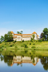 Fototapeta na wymiar Svirzh Castle reflected in lake water. Lviv region, Ukraine