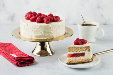 White cake with a wreath made of raspberries on the white background