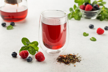 Raspberries and blueberries tea with fresh berries on white background